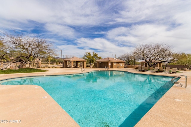 pool with a patio, fence, and a gazebo