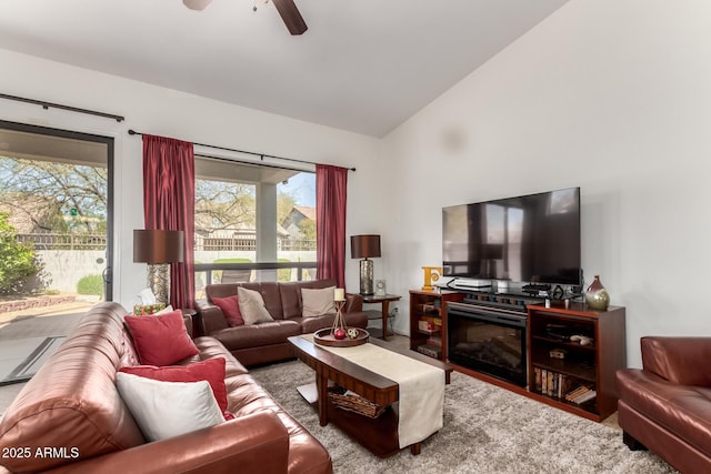 living area featuring lofted ceiling and a ceiling fan