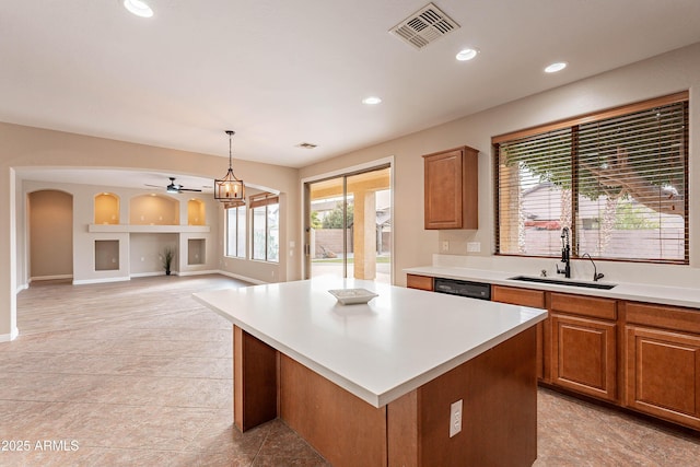 kitchen with a kitchen island, hanging light fixtures, a healthy amount of sunlight, and sink