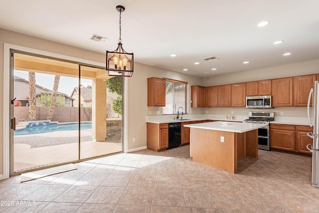 kitchen with a center island, sink, stainless steel appliances, an inviting chandelier, and decorative light fixtures