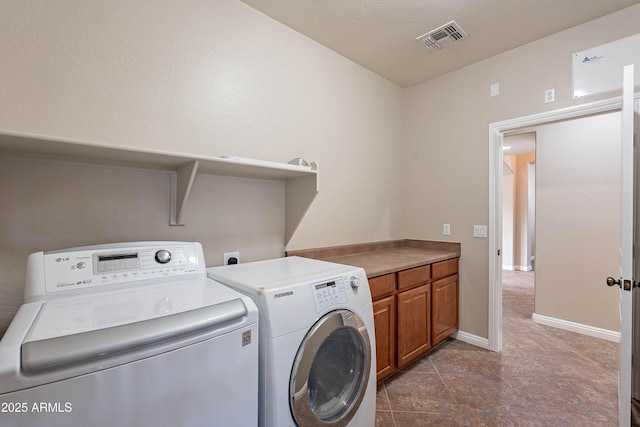 washroom featuring cabinets and independent washer and dryer