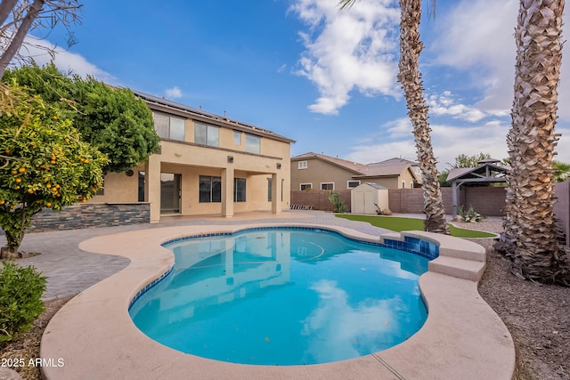 view of swimming pool featuring a patio area and a storage shed