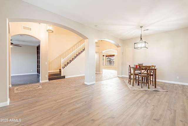 unfurnished dining area with ceiling fan and light wood-type flooring