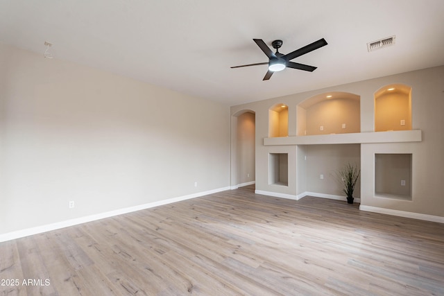 unfurnished living room with ceiling fan, built in features, and light wood-type flooring