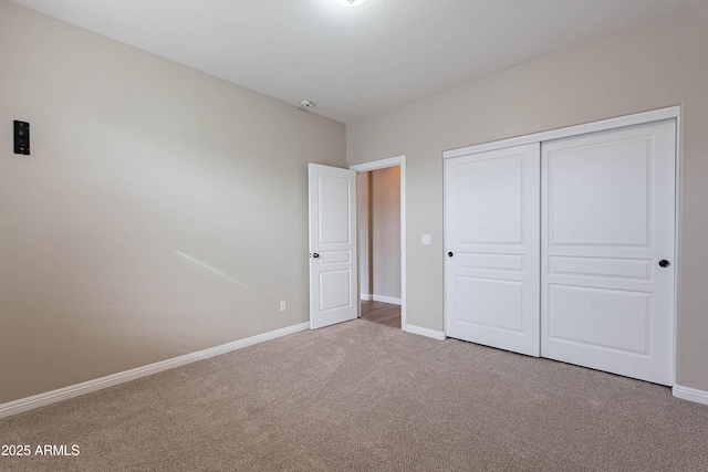 unfurnished bedroom with light colored carpet and a closet