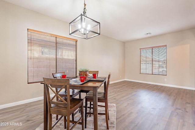 dining area featuring hardwood / wood-style floors and a notable chandelier