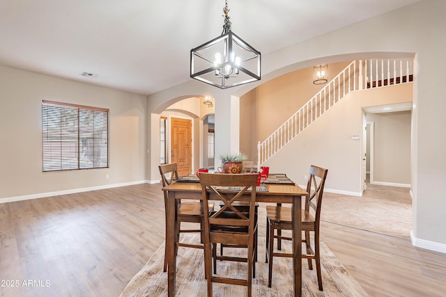 dining space featuring hardwood / wood-style flooring and a notable chandelier