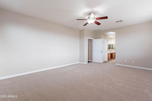 empty room featuring ceiling fan and light carpet