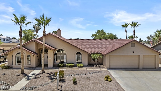 6249 E Camelot Dr, Mesa, AZ 85215 - mediterranean / spanish house featuring concrete driveway, stucco siding, an attached garage, a tiled roof, and a chimney