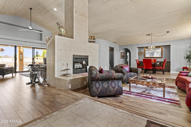 6249 E Camelot Dr, Mesa, AZ 85215 - living area featuring a ceiling fan, wood ceiling, arched walkways, wood finished floors, and a tiled fireplace