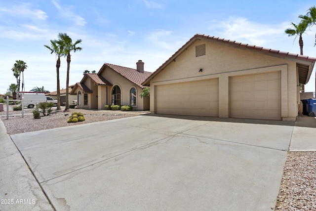 6249 E Camelot Dr, Mesa, AZ 85215 - mediterranean / spanish home with a tiled roof, stucco siding, concrete driveway, a chimney, and an attached garage