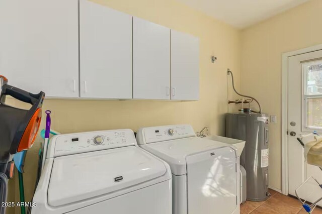 laundry room featuring cabinet space, light tile patterned flooring, washing machine and dryer, and water heater