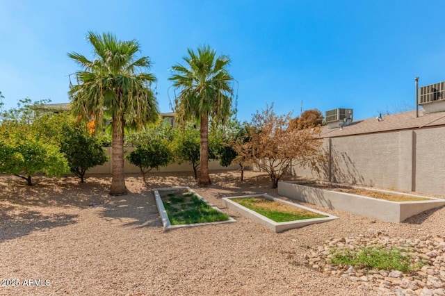 view of yard featuring a vegetable garden, cooling unit, and fence