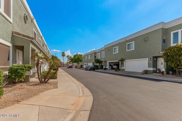 view of street with curbs, sidewalks, and a residential view