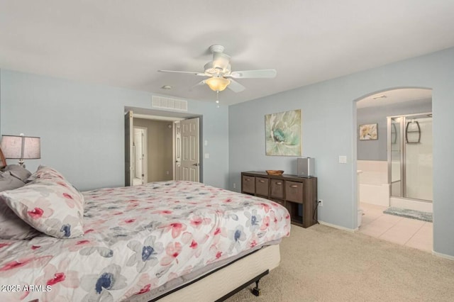 carpeted bedroom featuring visible vents, arched walkways, and ceiling fan