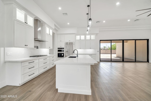 18225 W San Juan Ct, Litchfield Park, AZ 85340 - kitchen with wall chimney exhaust hood, stainless steel appliances, a sink, backsplash, and light countertops