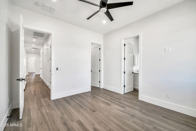 18225 W San Juan Ct, Litchfield Park, AZ 85340 - unfurnished bedroom with wood finished floors, baseboards, recessed lighting, ensuite bath, and ceiling fan
