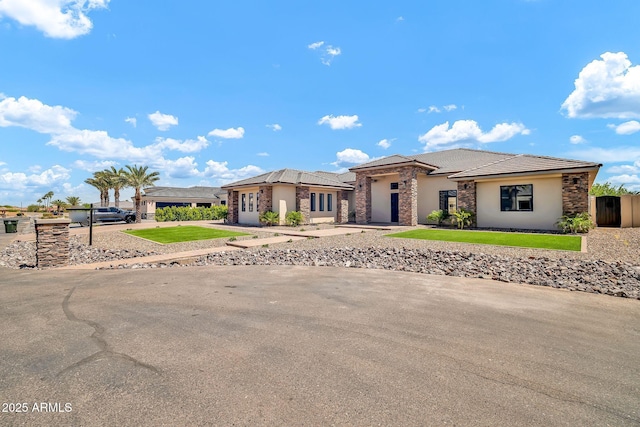 18225 W San Juan Ct, Litchfield Park, AZ 85340 - prairie-style home featuring stone siding, stucco siding, an attached garage, and a front yard