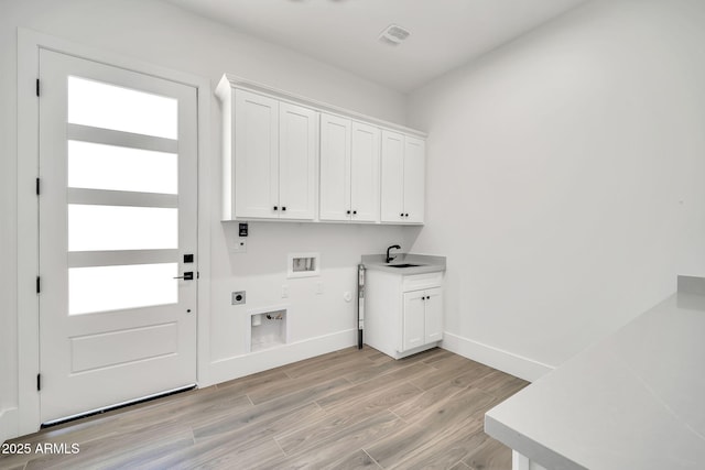18225 W San Juan Ct, Litchfield Park, AZ 85340 - laundry area featuring hookup for an electric dryer, washer hookup, cabinet space, light wood-type flooring, and gas dryer hookup