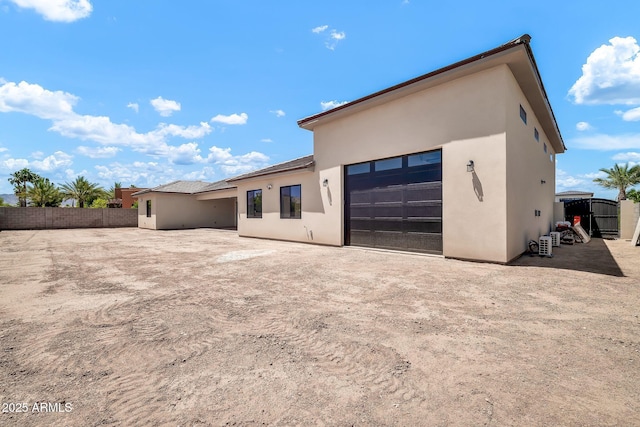 18225 W San Juan Ct, Litchfield Park, AZ 85340 - rear view of house with stucco siding, fence, and a garage