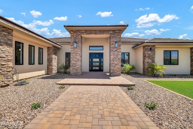 18225 W San Juan Ct, Litchfield Park, AZ 85340 - property entrance with stucco siding, a tiled roof, and stone siding