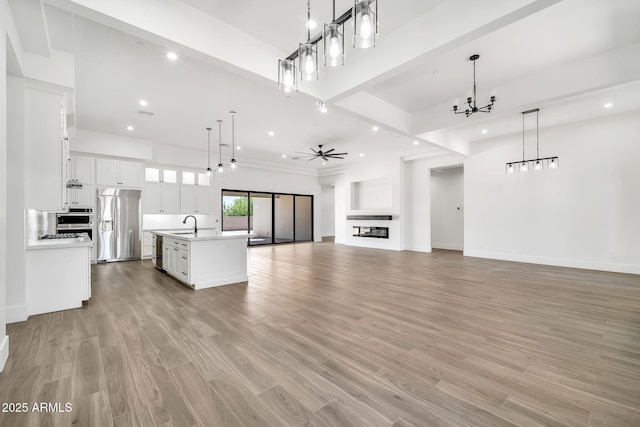 18225 W San Juan Ct, Litchfield Park, AZ 85340 - unfurnished living room with a chandelier, light wood-style floors, recessed lighting, ceiling fan, and baseboards