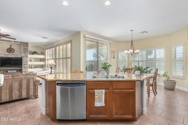 kitchen with pendant lighting, dishwasher, a center island with sink, sink, and light tile patterned floors