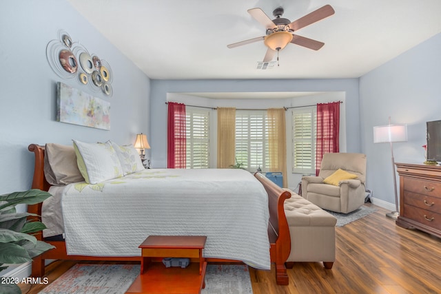 bedroom with dark hardwood / wood-style flooring and ceiling fan