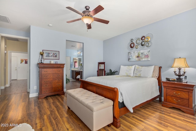 bedroom with connected bathroom, ceiling fan, and dark hardwood / wood-style flooring