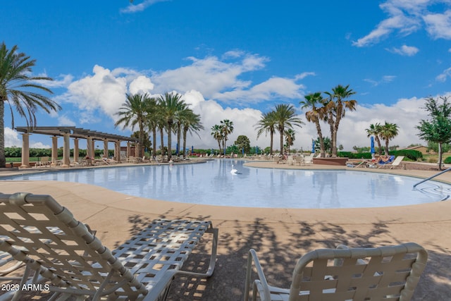 view of swimming pool with a water view and a patio area