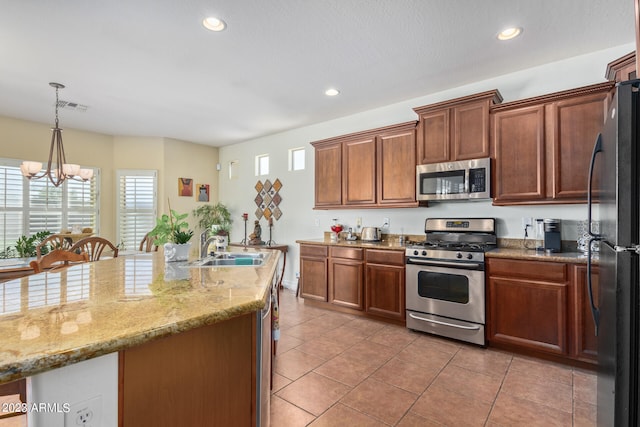 kitchen featuring sink, hanging light fixtures, light tile patterned floors, stainless steel appliances, and a chandelier