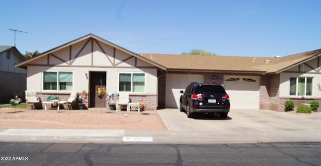 view of front of house with brick siding, driveway, and a garage