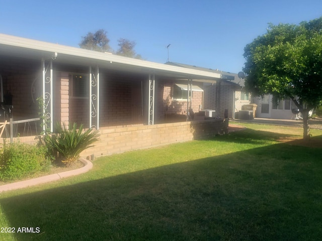 rear view of property with a lawn and brick siding