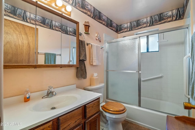 full bathroom featuring vanity, toilet, and bath / shower combo with glass door