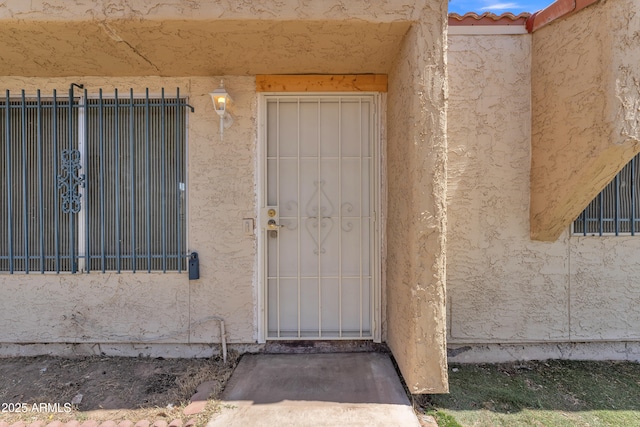 4836 W Rose Ln, Glendale, AZ 85301 - view of exterior entry with stucco siding, fence, and a tiled roof