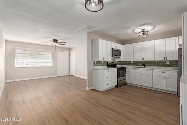 kitchen featuring white cabinetry, hardwood / wood-style flooring, and appliances with stainless steel finishes