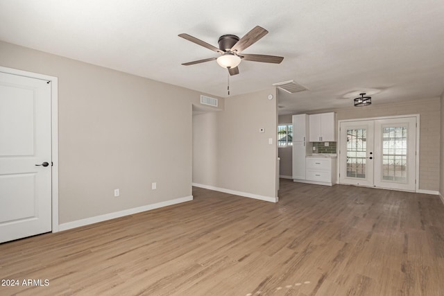 unfurnished living room with french doors, light wood-type flooring, and ceiling fan