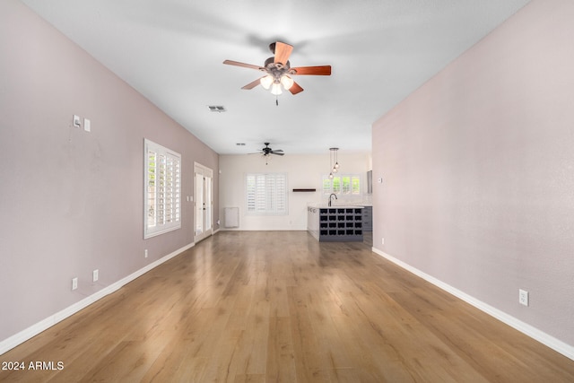 unfurnished living room featuring hardwood / wood-style flooring and ceiling fan