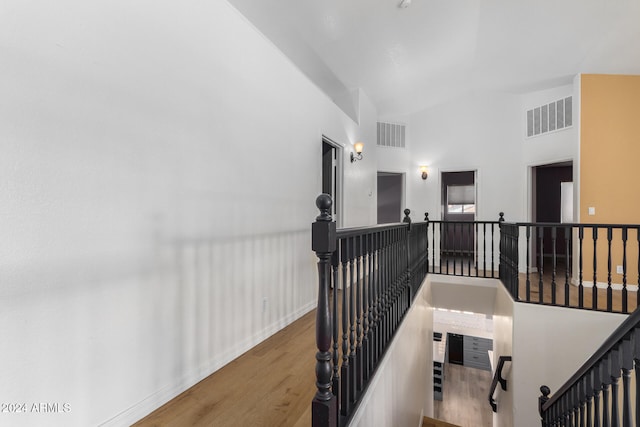 hallway featuring hardwood / wood-style floors and high vaulted ceiling