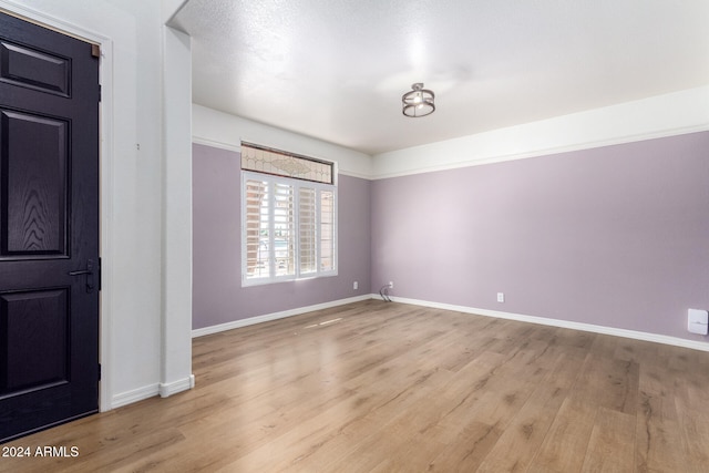 foyer entrance featuring a textured ceiling and light hardwood / wood-style flooring