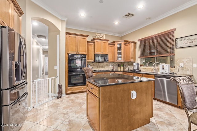 kitchen with backsplash, a kitchen island, ornamental molding, black appliances, and sink