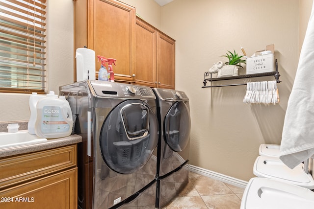 washroom featuring cabinets, light tile patterned flooring, and separate washer and dryer