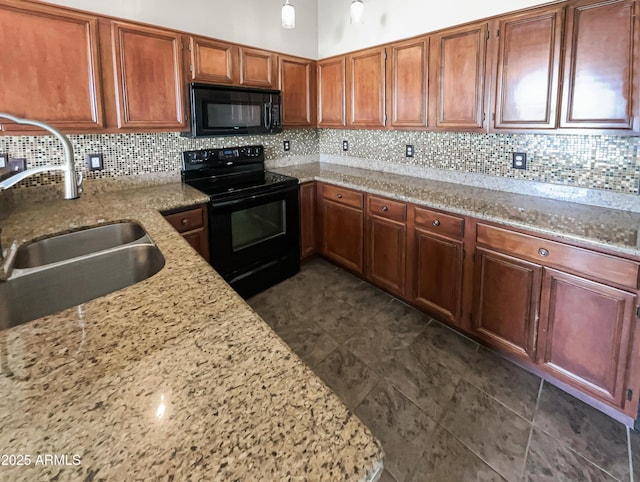 kitchen featuring decorative backsplash, light stone countertops, brown cabinets, a sink, and black appliances