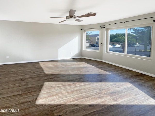 empty room with baseboards, ceiling fan, and wood finished floors