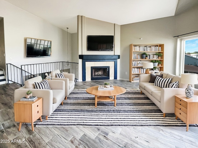 living area featuring lofted ceiling, a fireplace, and wood finished floors