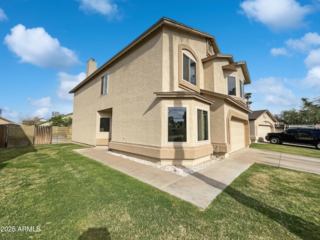 view of home's exterior featuring fence, a chimney, concrete driveway, stucco siding, and a yard