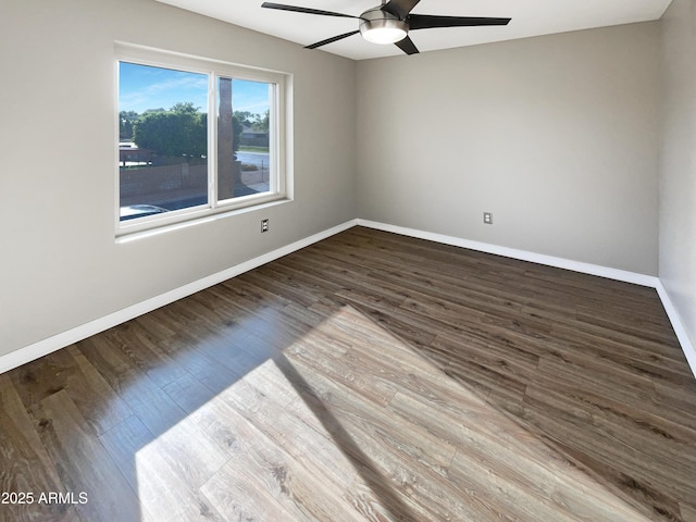 empty room featuring baseboards, ceiling fan, and wood finished floors