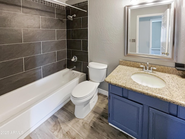 full bathroom featuring shower / bathing tub combination, vanity, toilet, a textured wall, and wood finished floors