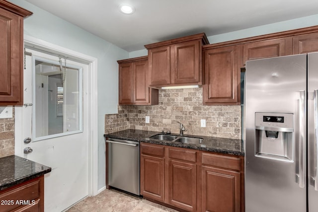 kitchen featuring backsplash, sink, dark stone counters, and appliances with stainless steel finishes