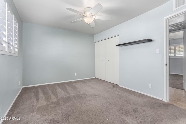 unfurnished bedroom featuring carpet floors, a closet, and ceiling fan